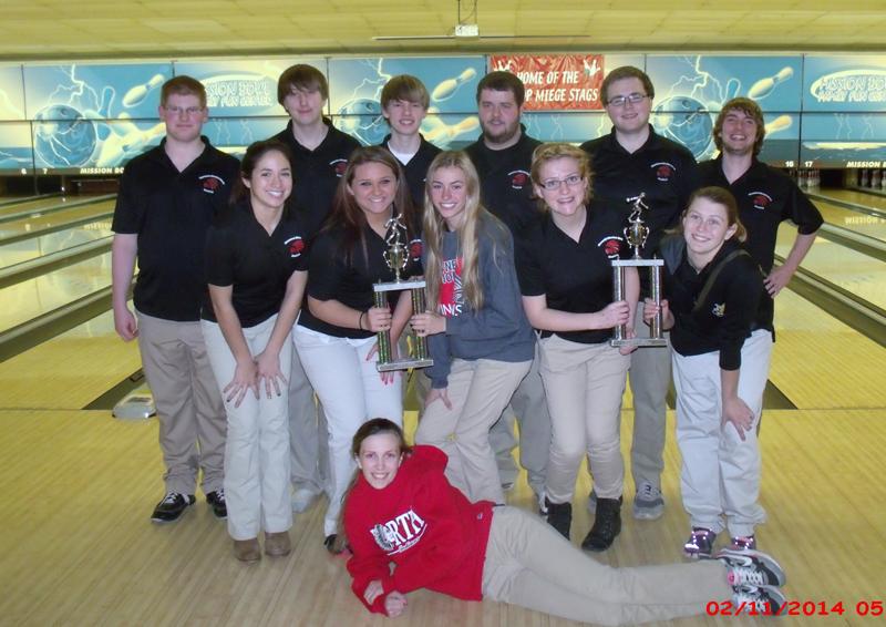 The bowling team holds up the trophy after winning the district championship.
