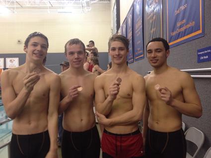 Standing in a line after winning the 400 free relay seniors Cody Sarras, Erik Hydeman, Lair Heslop and sophomore Charlie Kaifes show off the medals they won.