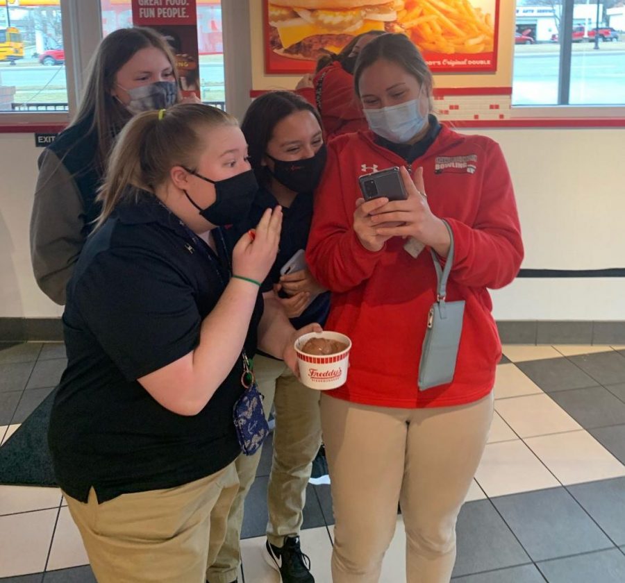 Senior Kayla Anderson right)hold her phone while reading off the results of regionals. 