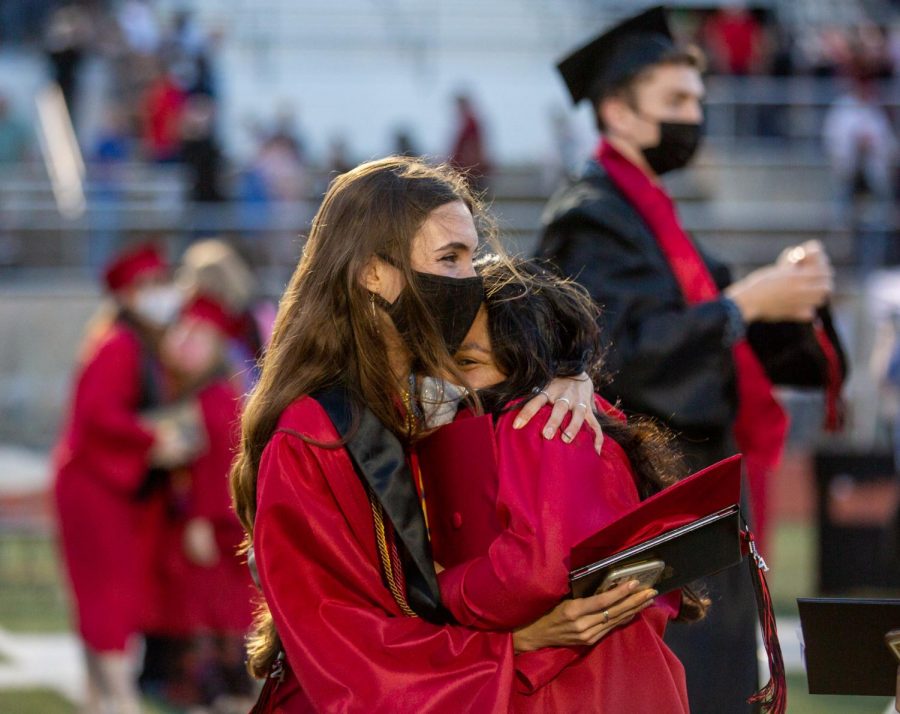 Graduates Emma Bell and Elizeth Moncada embracing after the ceremony.  