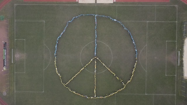 A peace signs formed by the students at my german school. The blue and yellow are a tribute to Ukraines flag. 