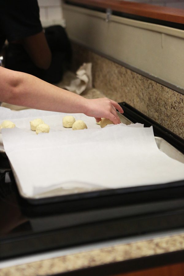 Carefully grabbing the dough from the mixer, junior Amarista Gutierrez rolls the dough into balls. Gutierrez stood in front of the oven placing the dough on the tray, trying her best to use all of it up. “I felt good, Gutierrez said it was nice to work with my friends.”
